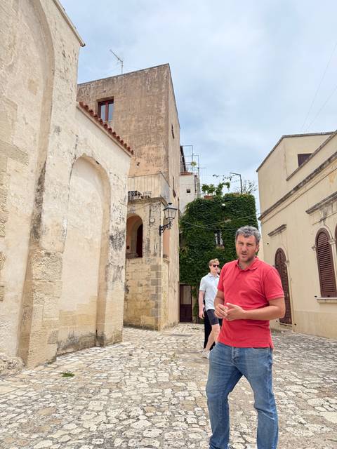       Two people standing in an old courtyard.
  
