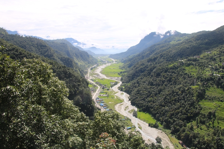 Panoramic view of a lush valley with a river.