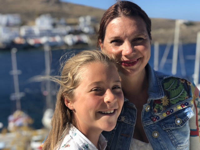 Portrait of a woman and a child with a marina in the background.
