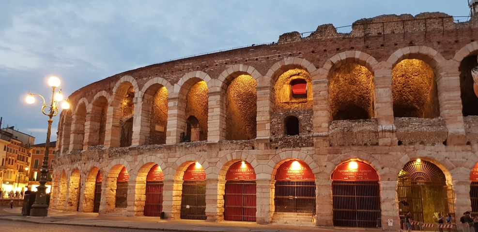 A historic colosseum structure lit up in the evening.