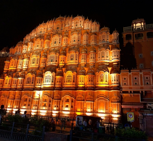 Ornately lit palace facade at night with warm illumination.