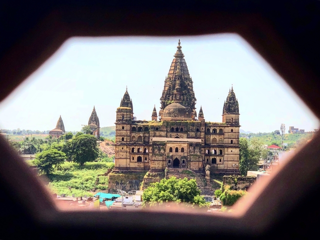 Historic temple with domed architecture surrounded by greenery.