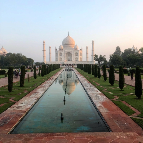 The Taj Mahal and its reflecting pools lined with trees.