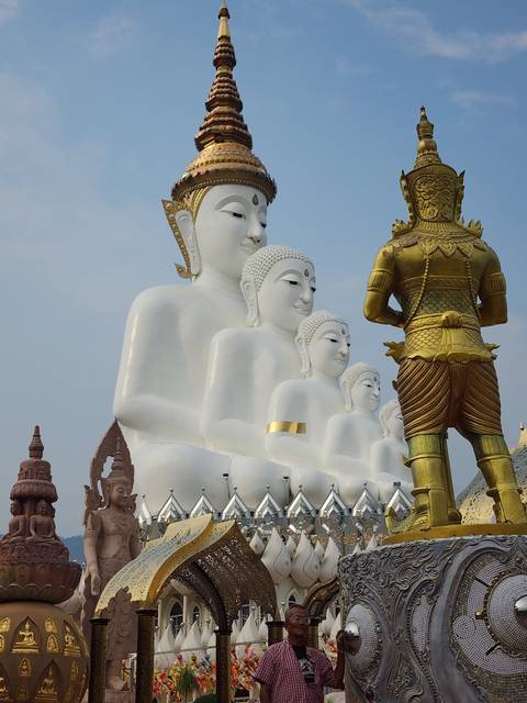 Large white Buddha statues in a temple setting.