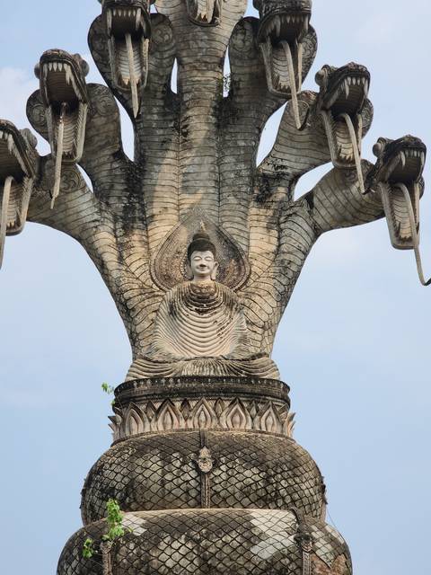 Statue of Buddha with multiple heads atop.