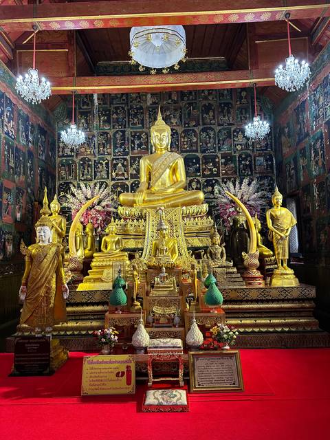 Ornate gold Buddha statue in a decorated interior.