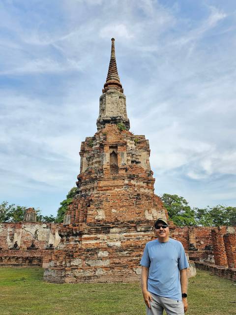 Person standing by an ancient temple ruin.