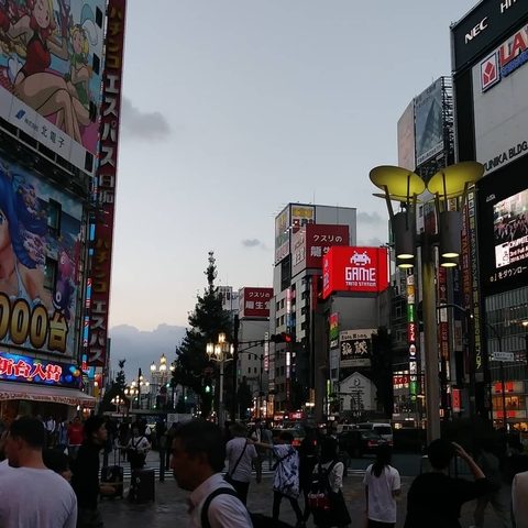 Bustling urban street with brightly lit signs and advertisements.