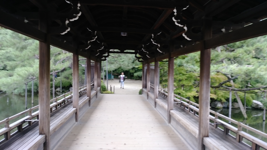Blurred view of a temple walkway with a person in the distance.