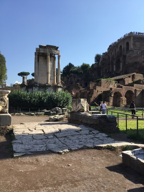 Ancient ruins with people walking around in a bright day.