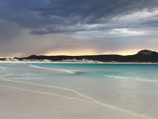       A beautiful coastal view with turquoise water and sandy beach.
  