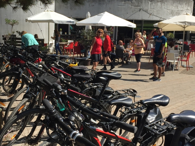A group of people and bicycles at an outdoor cafe.