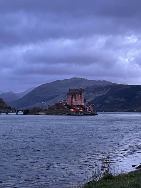       Castle surrounded by water at dusk.
  