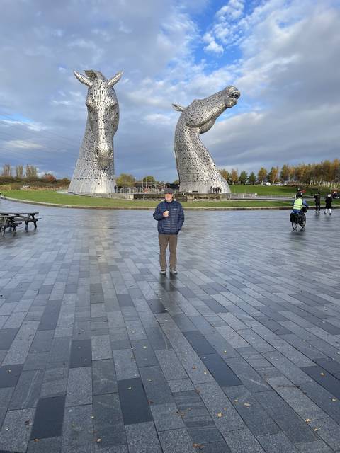       Giant horse head sculptures with a person.
  