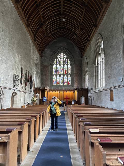       Cathedral interior with rows of pews and stained glass windows.
  