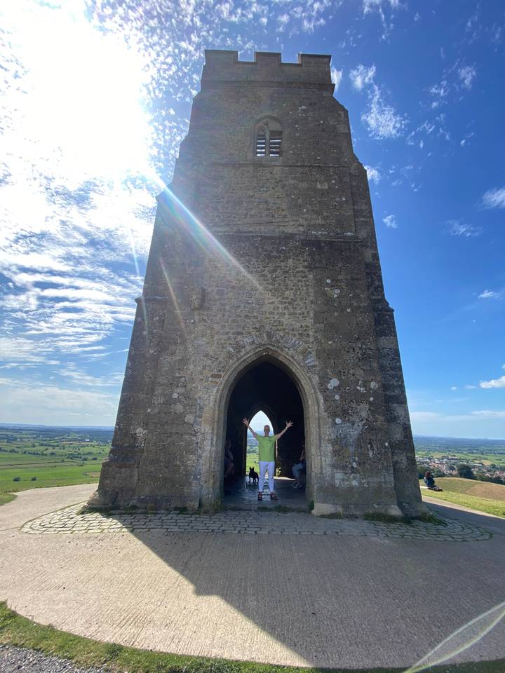 Stone structure with arched opening and sunlight.