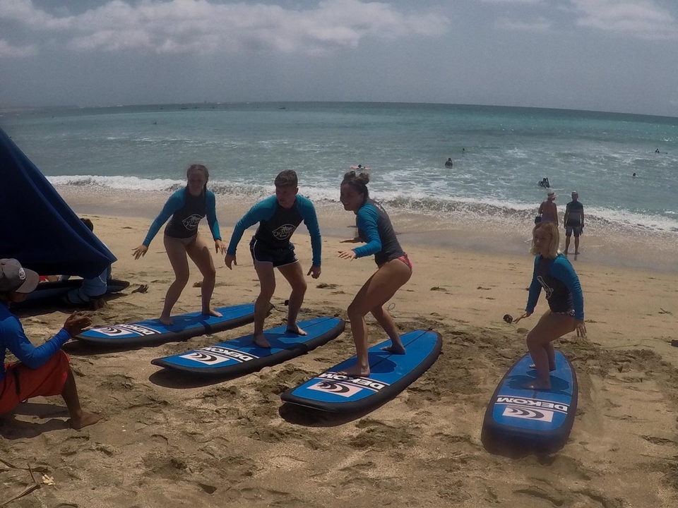 Group surfing lesson on the beach with instructors.