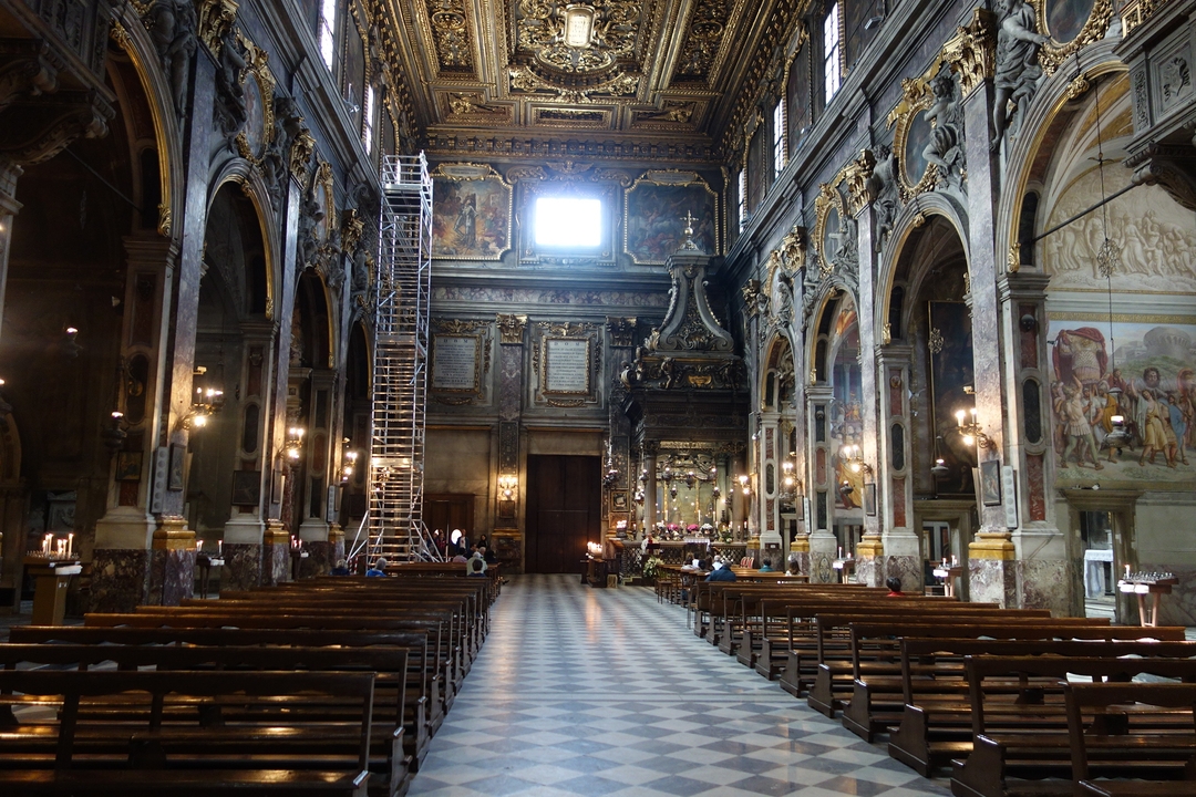 Interior of an ornate church with visitors.