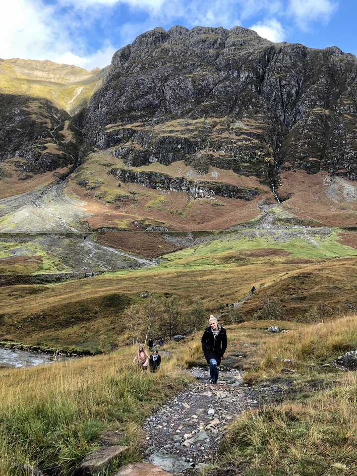 Randonneurs profitant de la vue dans une vallée entourée de montagnes.