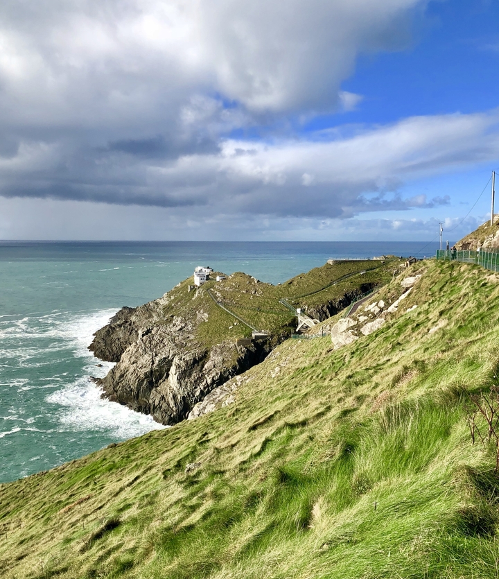 Coastal view of a rocky headland with a lighthouse.