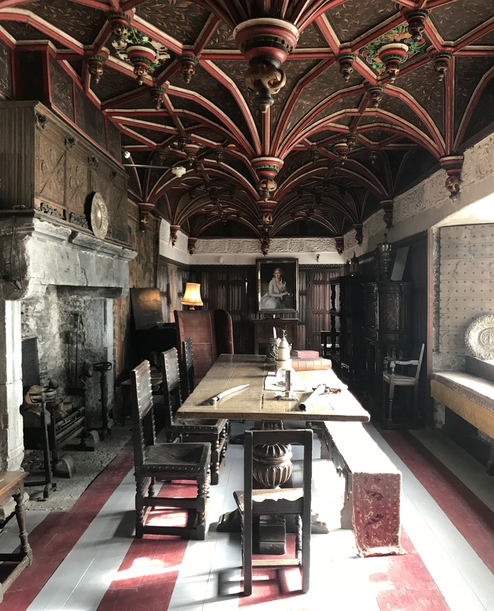 Interior of an ancient building with a wooden table and a vintage painting.