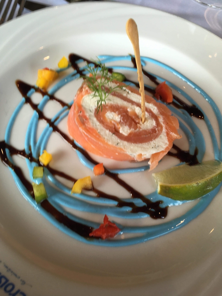 Plat abstrait au saumon avec des garnitures colorées.