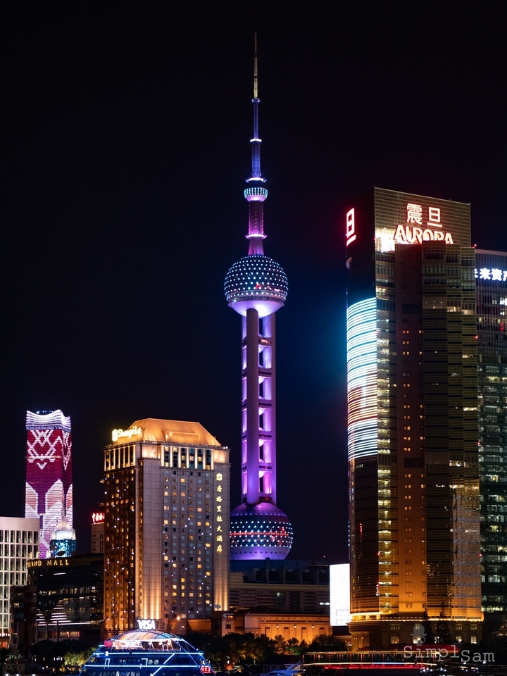 Skyline urbain avec une tour remarquable la nuit.