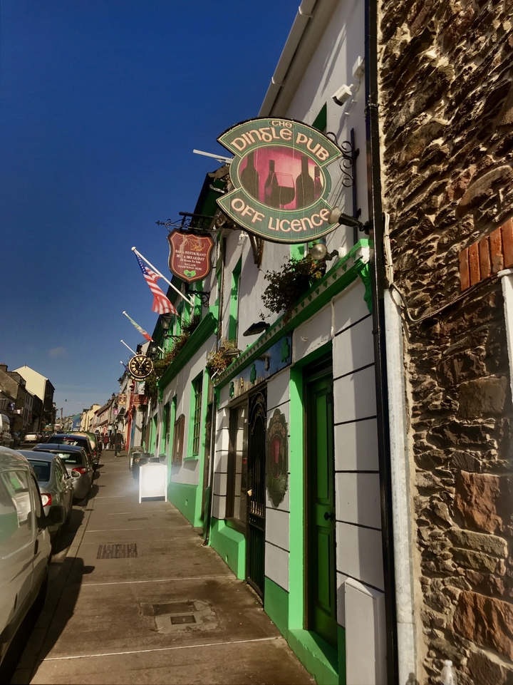 Kleurrijke straat met pubs en winkels.