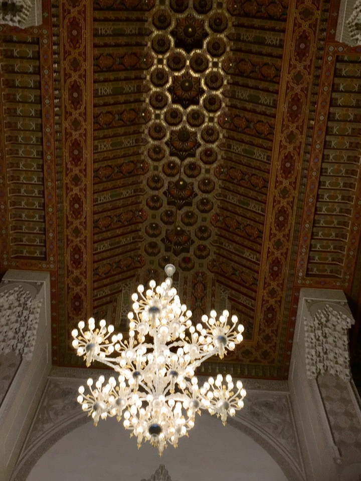 Ornate ceiling with a chandelier in a historical building.