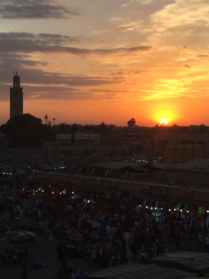 Sunset view over Marrakesh with a silhouette of a city skyline.
