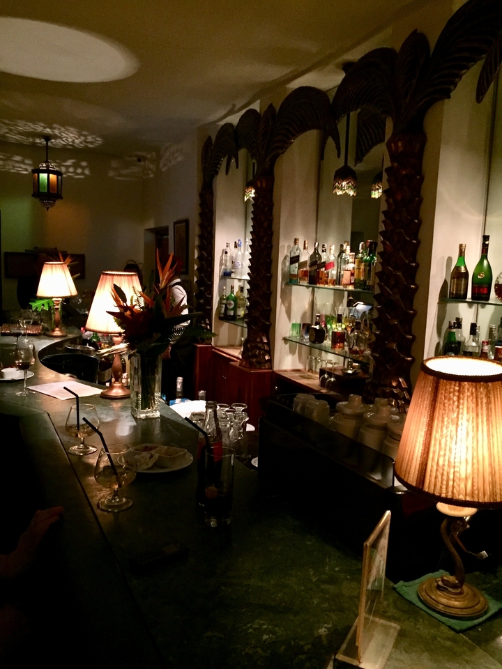 Cozy bar interior with bottles and soft lighting.