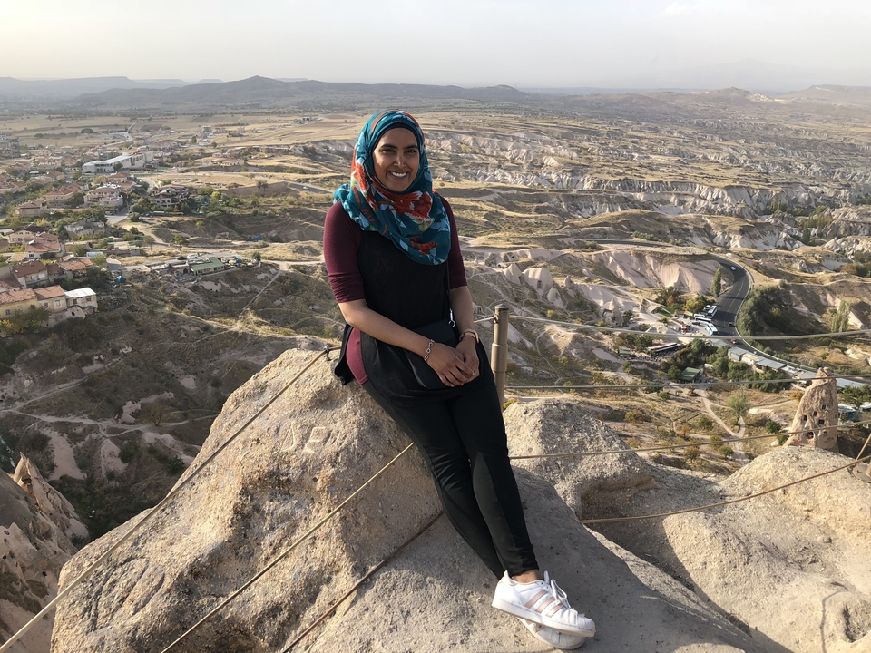 Person sitting on rocks with a panoramic view.