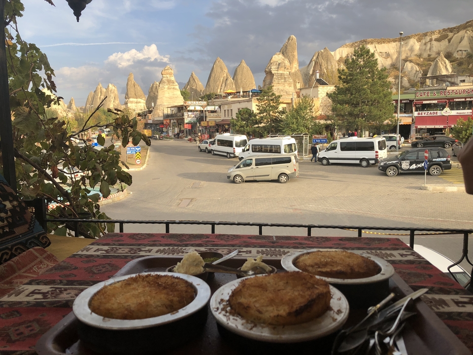 View of street with fairy chimneys and dessert on table.