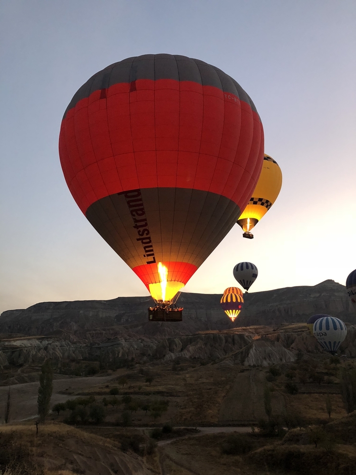 Hot air balloon in flight with others in the background.