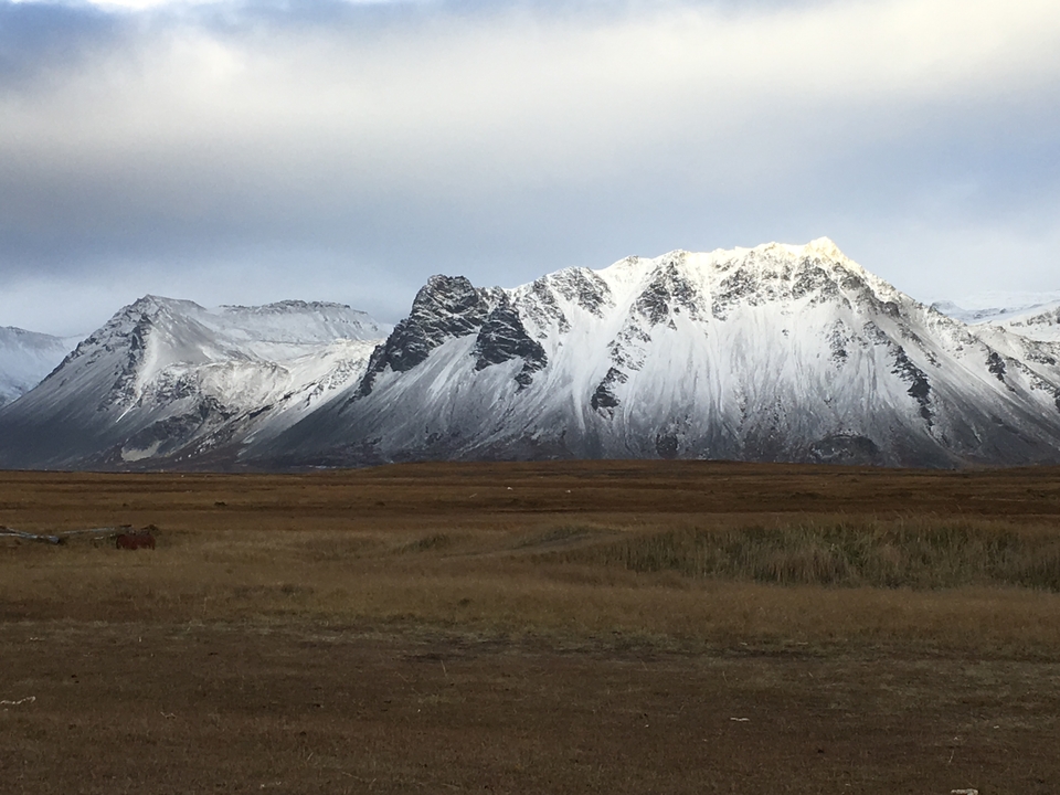 Snow-capped mountains under a cloudy sky.