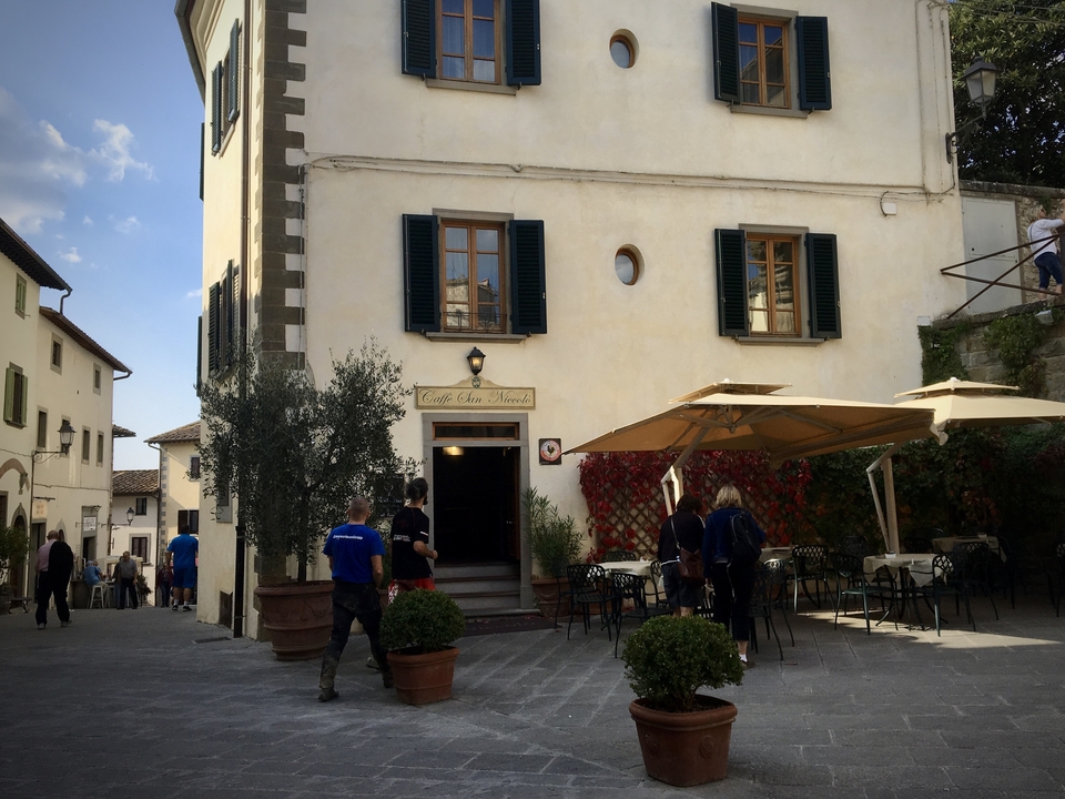 Des gens près d'un café avec un bâtiment rustique.