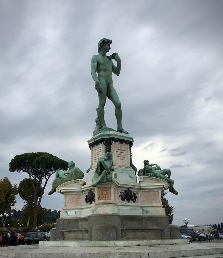 A bronze statue of a man surrounded by reclining figures.