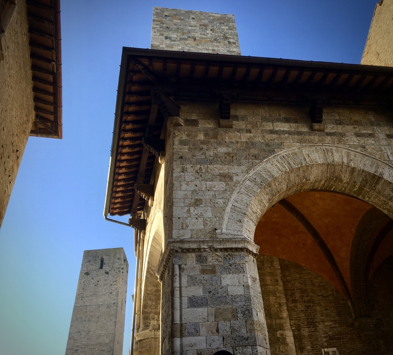 Bâtiment historique en pierre avec arches et tour.