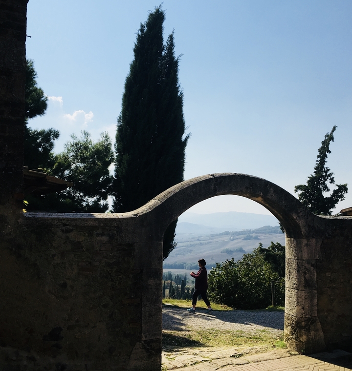 Vue panoramique à travers une arche avec la silhouette d'une personne.