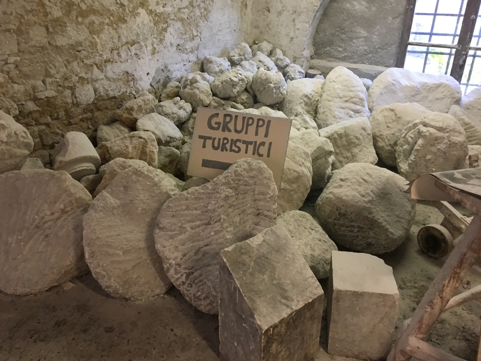 Vue intérieure d'un espace avec des rochers et un panneau indiquant « Gruppi Turistici ».