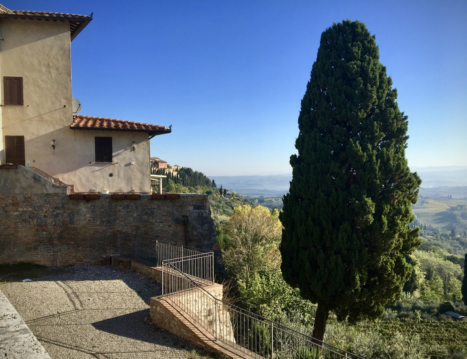 Vue panoramique de la campagne avec une maison et des arbres.