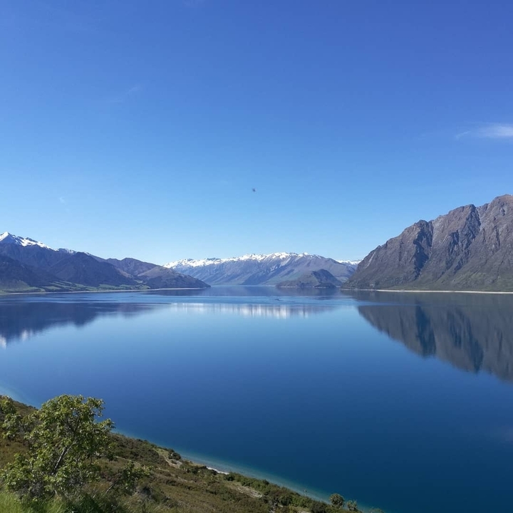 A serene lake with reflections of snow-capped mountains.