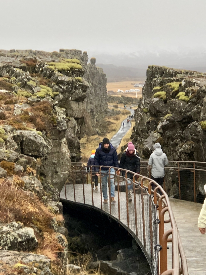 People walking along rocky terrain with a path.