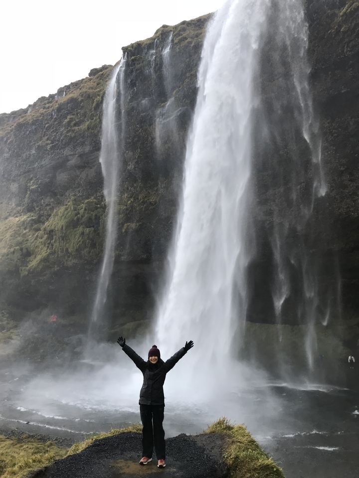 Waterfall cascading down a cliff with mossy rocks.