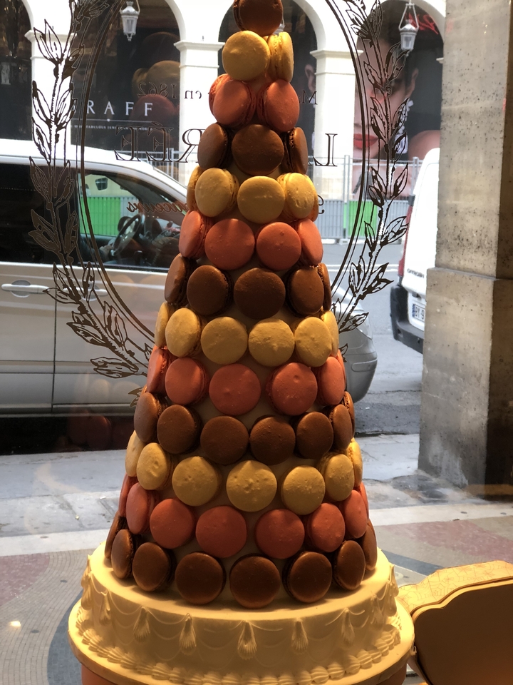 Présentation de macarons colorés empilés en forme de pyramide.
