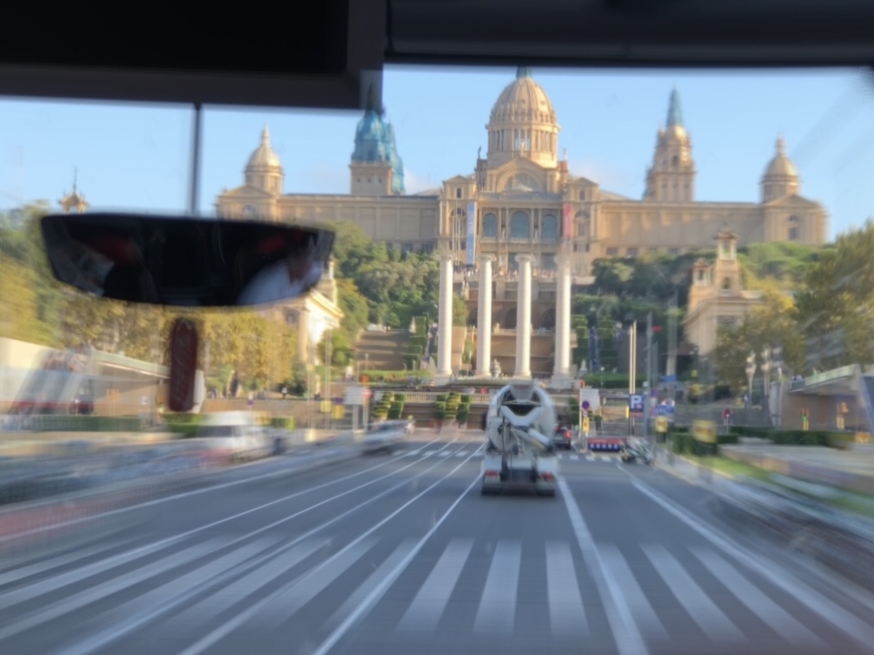 Image floutée par le mouvement du Museu Nacional d'Art de Catalunya avec un reflet dans une vitre de bus.