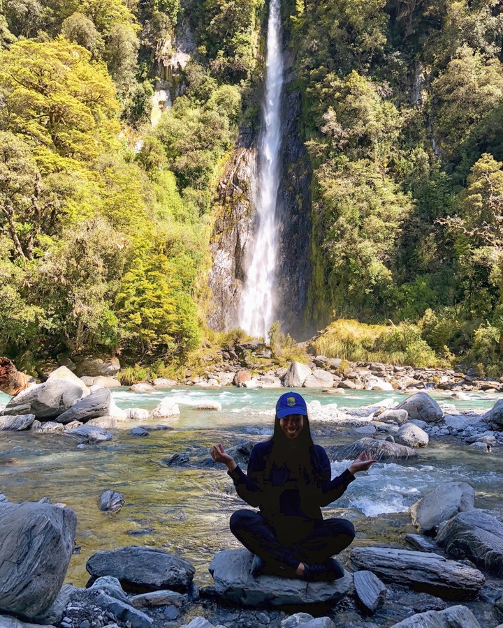 Person with a waterfall in the background.
