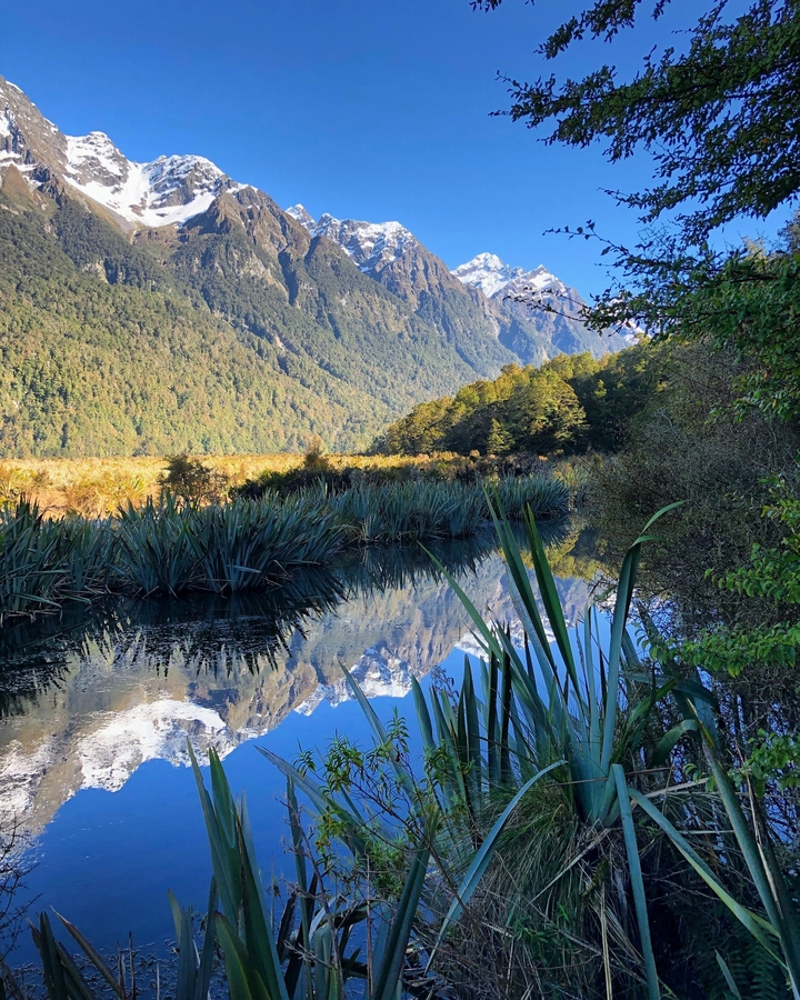 Landscape with mountains reflected in a lake.