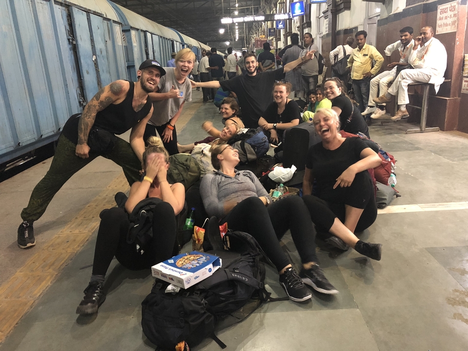 Groupe de voyageurs assis et se détendant sur un quai de gare.