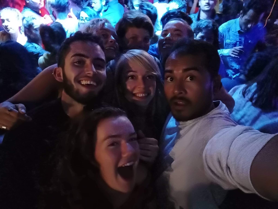 Selfie de groupe dans un éclairage tamisé lors d'un rassemblement social.